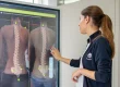 Fisioterapeuta a analisar o alinhamento da coluna vertebral através de tecnologia de avaliação postural