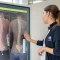 Fisioterapeuta a analisar o alinhamento da coluna vertebral através de tecnologia de avaliação postural