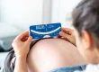 Fisioterapeuta a realizar medição clínica da escoliose com escoliómetro durante avaliação da coluna