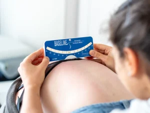 Fisioterapeuta a realizar medição clínica da escoliose com escoliómetro durante avaliação da coluna
